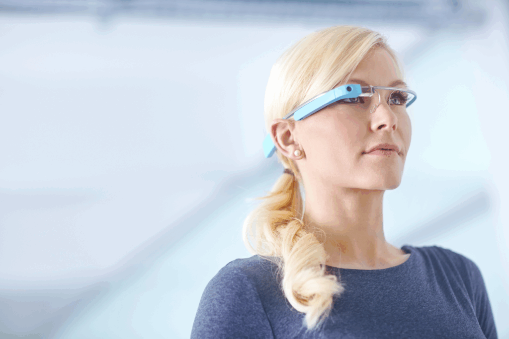 Blond kvinna med tech-glasögon tittar åt höger.