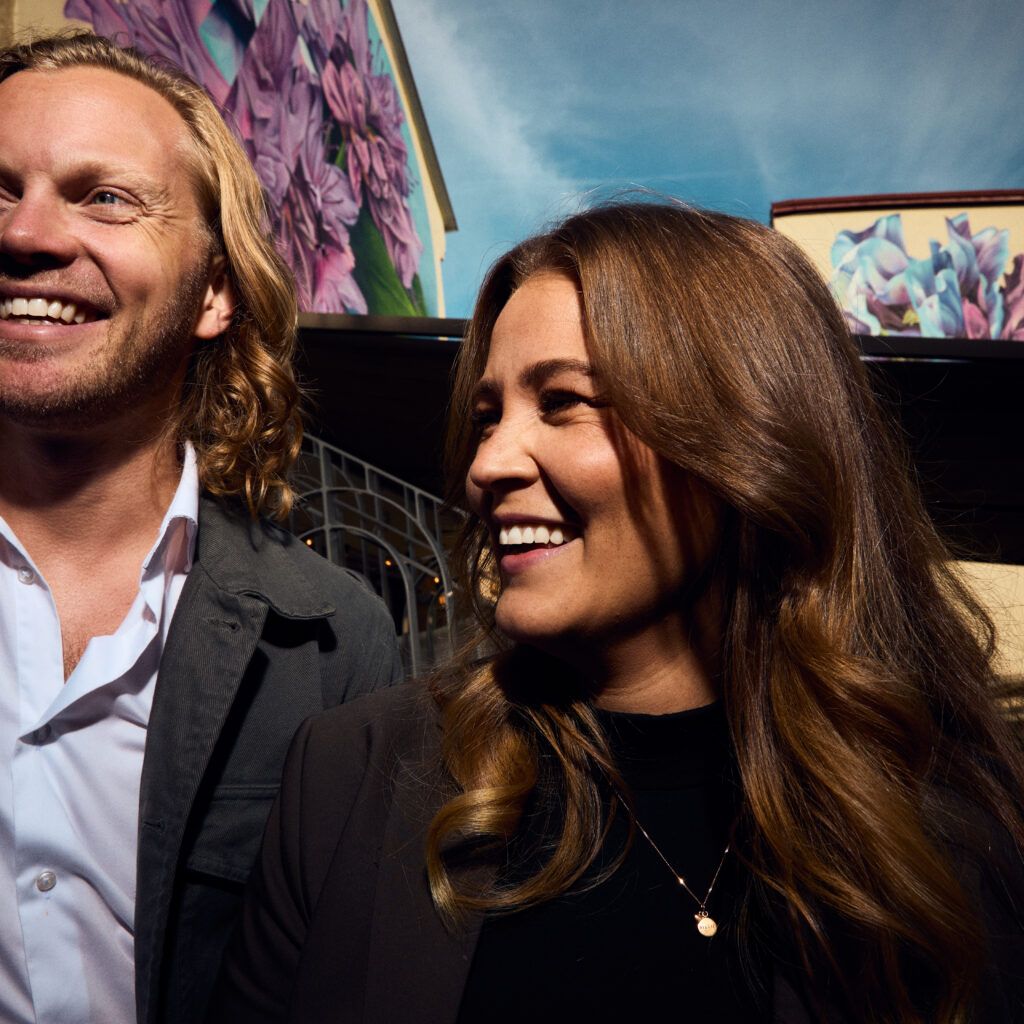 Två glada kollegor i solig utomhusmiljö, från vänster Charles Sinclair, grundare och head of employer branding samt Daniella Ravan CEO.